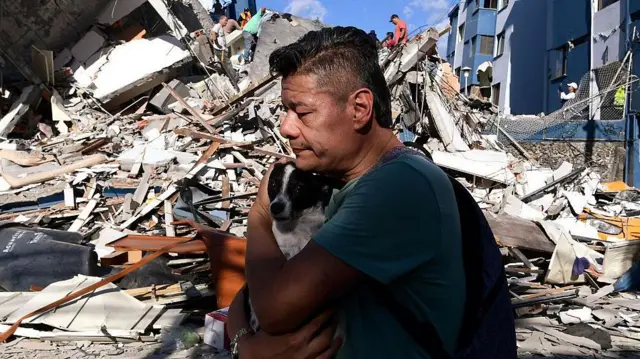 Hombre abraza a su perro rescatado frente a los escombros tras el terremoto